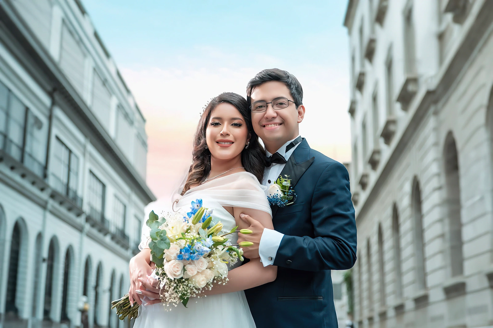 Los novios frente a los edificios blancos